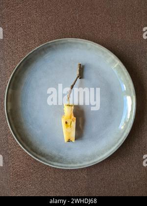 Ein bis in den Kern und den Stiel geschnittener Apfel liegt stilvoll auf einem Teller Stockfoto