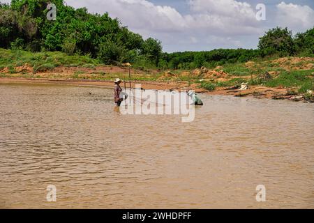 SIEM Reap, Kamboda, 6. Juli 2019-Dorfbewohner werfen Netze für Fische in den schlammigen Gewässern des Siem Reap Flusses in Siem Reap, Kambodscha Stockfoto