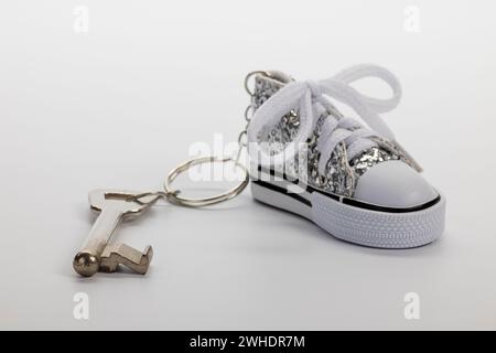 Zimmerschlüssel mit Sneakers Schlüsselanhänger, Miniatur-Sneaker, bunter Barschlüssel, weißer Hintergrund, Stockfoto