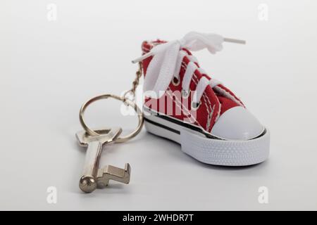 Zimmerschlüssel mit Sneakers Schlüsselanhänger, Miniatur-Sneaker, bunter Barschlüssel, weißer Hintergrund, Stockfoto