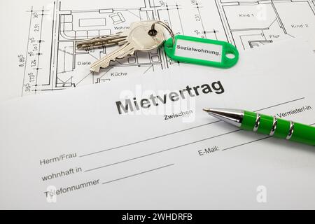 Schlüsselanhänger mit grünem Schlüsselanhänger, Aufschrift „Sozialwohnungen“, Mietvertrag, Kugelschreiber, Grundriss, Stockfoto