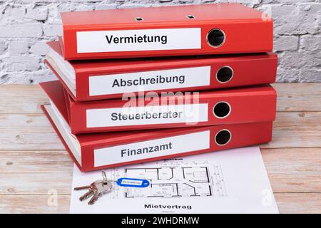 Rote Aktenordner mit der Aufschrift Vermietung, Abschreibung, Steuerberater, Finanzamt, Schö¸sselbund, Blue Schö¸sselanö€°nger beschriftet mit ëRentalë, Grundriss, Mietvertrag, Detail, Symbolbild, Aufbewahrungsfristen, Steuerbelege, Stockfoto