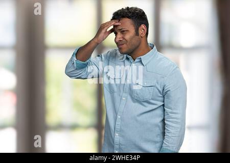 Verärgert frustrierter junger Mann, der unter starken Kopfschmerzen leidet. Gesundheitskonzept. Stockfoto