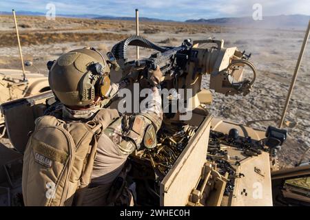 Der Senior Airman Collin Domingo, Mitglied des taktischen Eingreifteams der 9th Security Forces Squadron, Beale Air Force Base, Kalifornien, feuert am 30. Januar 2024 in Fallon, Nevada, ein Maschinengewehr mit einem Kaliber .50 auf einem minenbeständigen, überfallsicheren All-Terrain Vehicle (M-ATV) ab. Das M-ATV ist mit dem Common Remote Operated Weapon Station (CROWS)-System ausgestattet, mit dem Computer gezielt und ferngesteuert gesteuert werden können. (Foto der U.S. Air Force von Tech. Sgt. Samuel A. Burns) Stockfoto