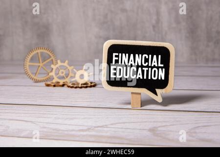 Text Financial Education auf Finanztischen mit Stift, Puper Clips und Lupe. Geschäfts- und Finanzkonzept. Stockfoto
