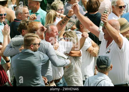 '03.09.2023, Deutschland, Baden-Wuerttemberg, Iffezheim - Leute jubeln bei einem Pferderennen an, nachdem sie eine Wette gewonnen haben. 00S230903D417CAROEX.JPG [MODELLVERSION: NEIN, Stockfoto