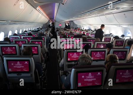 '30.10.2023, Quatar, Doha - Passagiere in einer Flugzeugkabine erhalten bei der Einreise in das Land über das Bordnetz Informationen über Zollvorschriften Stockfoto