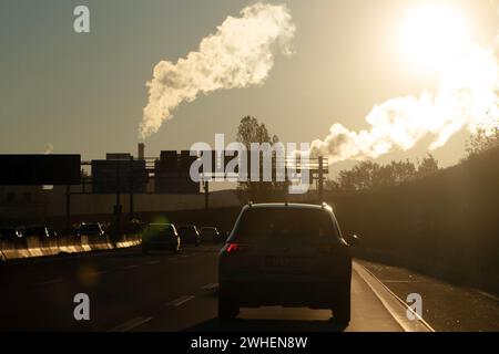 '22.11.2023, Deutschland, Berlin, Berlin - Rauchen von Industrieschornsteinen gegen das Licht auf der A113. 00S231122D137CAROEX.JPG [MODELLVERSION: NEIN, EIGENSCHAFT Stockfoto