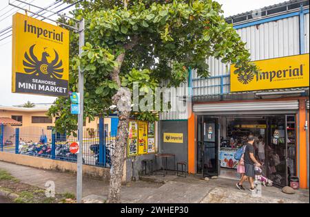 Costa Rica, Puntarenas - 22. Juli, 20.23: Seepferdchen Mini Markt Lebensmittelgeschäft mit großen Imperial Bier Schildern. Leute vor uns. Motorräder auf Parkplatz Stockfoto