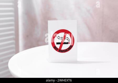Rauchverbot auf dem weißen Tisch drinnen Stockfoto