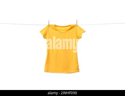 Gelbes T-Shirt, das auf der Wäscheleine vor weißem Hintergrund trocknet Stockfoto