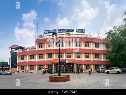 Mysore, Karnataka, Indien-16. Oktober 2023: Farbenfrohes Gebäude des Bahnhofs Mysuru mit schönem blauen Himmel und Wolken. Text in der Landessprache i Stockfoto