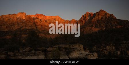 Schatten beginnen den Mount Kinesava und den West Temple im Hinterland des Zion Nationalparks zu verschlingen Stockfoto