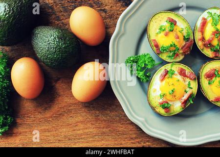 Avocado Eierboote mit Speck auf Holztisch. Draufsicht. Stockfoto