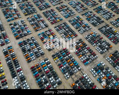 Peking, China. Februar 2024. Ein Foto der Luftdrohne vom 8. Februar 2024 zeigt Fahrzeuge für Exportparkplätze am Landhafen Ningde in Ningde, südöstlicher chinesischer Provinz Fujian. Der Landhafen von Ningde mit Eisenbahnlinien für den Fahrzeugtransport sowie Be- und Entladeplattformen diente als Logistikzentrum und Versandzentrum für Fahrzeuge, die in globale Märkte exportiert werden sollen. Quelle: Zhou Yi/Xinhua/Alamy Live News Stockfoto