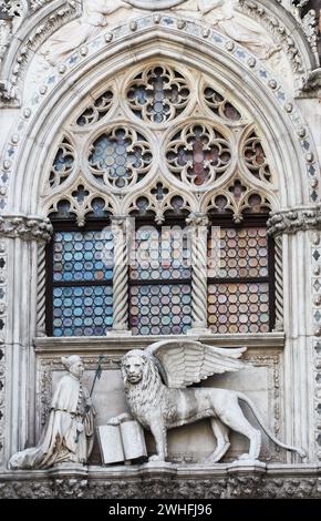 Venezianischer Löwe und Doge in einem Dom-Gebäude auf dem Markusplatz in Venedig, Italien. Venedigs Symbol der geflügelte Löwe Stockfoto