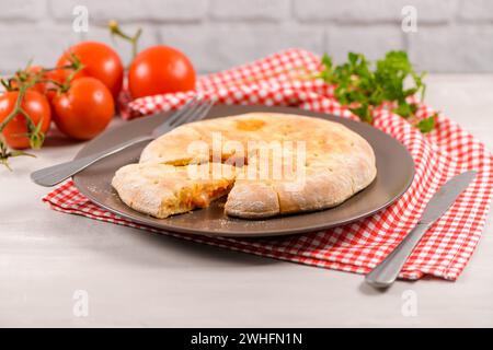 Pizza Calzone auf hölzernem Hintergrund Stockfoto