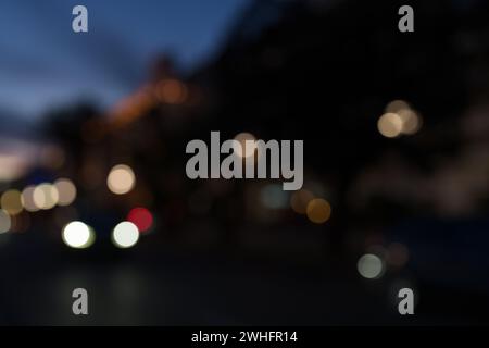 Bokeh Hintergrund von Autos, die nach Sonnenuntergang am Strand entlang fahren, zurück fahren Stockfoto