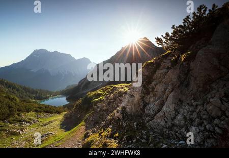 Wunderschöner Sonnenaufgang über Berggipfeln und See Stockfoto