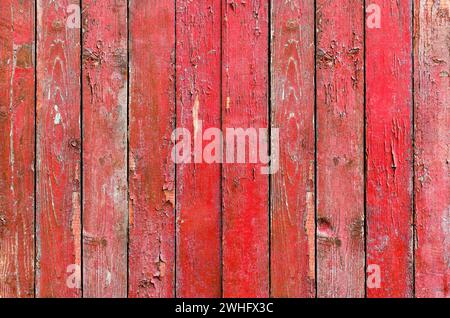 Roter Holzhintergrund, verwitterter Holzzaun mit abblätternder Farbe Stockfoto