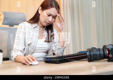 Professionelle Fotografin, die sich bei der Bearbeitung von Fotos zu Hause mit der Arbeit beschäftigt Stockfoto