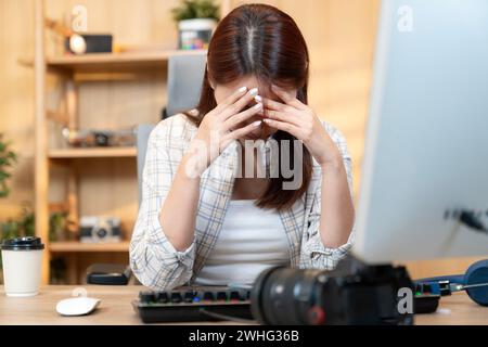 Professionelle Fotografin, die sich bei der Bearbeitung von Fotos zu Hause mit der Arbeit beschäftigt Stockfoto