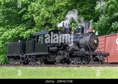 Blick auf eine antike Shay Dampfmaschine, die langsam Rauch und Dampf an einem sonnigen Tag bläst Stockfoto