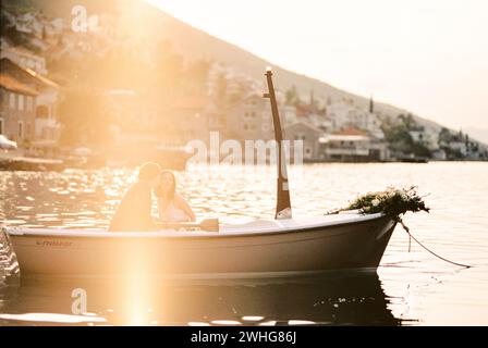 Mann und Frau sitzen in einem Boot mit Rudern in der Nähe des Ufers Stockfoto