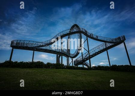 Tiger and Turtle, eine begehbare Achterbahnskulptur auf dem Magic Mountain vor einem dunklen, bewölkten Himmel zur blauen Stunde, Kunstinstallation Stockfoto