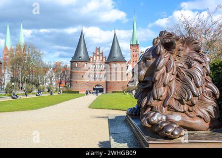 Lübeck, 11. April 2022: Löwenstatue aus Eisen vor dem Holstentor oder Holstentor, Wahrzeichen der Geschichte Stockfoto