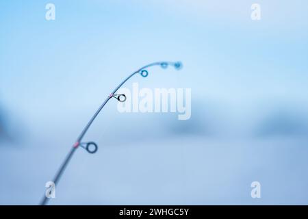 Die Angelstange wird leicht von einem Fisch am Haken gebogen Stockfoto