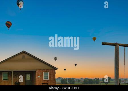 Start von Heißluftballons bei Sonnenaufgang am Vormittag während eines Ballonfestivals Stockfoto