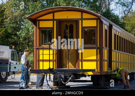 Einbau eines neuen gelben Reisezugwagens auf einer Eisenbahnstrecke Stockfoto