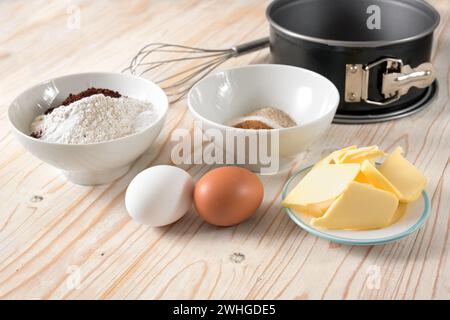 Zutaten für einen Kuchen wie Mehl, Eier, Butter und Zucker auf einem Holztisch, Backkonzept zu Hause, Kopierraum, ausgewählter Fokus, Stockfoto