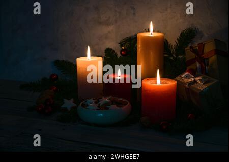 Kerzenlicht im Dunkeln, vier Adventskerzen, Zimtsternkekse und Tannenzweige als Dekoration in der Weihnachtszeit, Kopie s Stockfoto