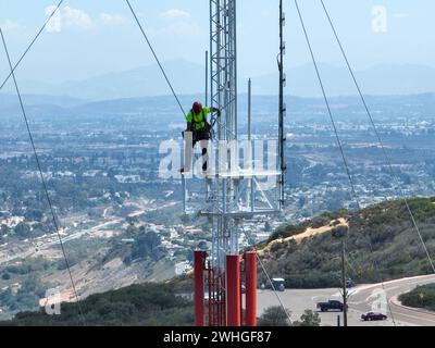 Ingenieur mit Sicherheitsausrüstung auf hohem Turm für die Wartung der Telekommunikationskommunikation. Stockfoto
