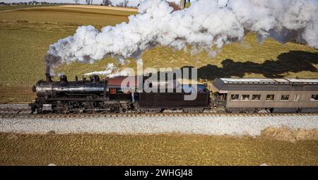 Parallelansicht eines restaurierten antiken Dampfzug, der durch die Landschaft fährt Stockfoto