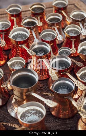 Viele goldene Kupferkessel oder -Töpfe, die für die Zubereitung von türkischem Kaffee verwendet werden. Stockfoto