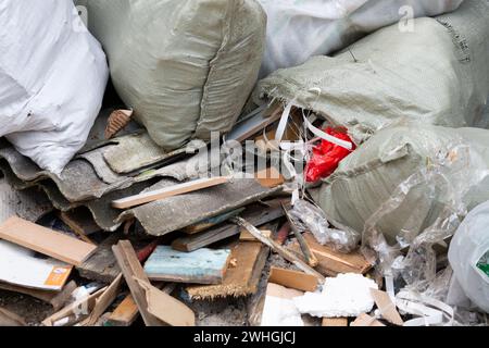 Ein Haufen Bauschutt in weißen Säcken in der Nähe eines neuen Gebäudes, Müll in Säcken Stockfoto