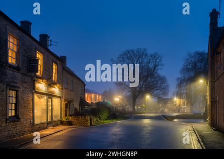 Nebelaufgang entlang der Sherborne Street im februar. Bourton on the Water, Cotswolds, Gloucestershire, England Stockfoto