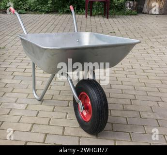 Schubkarre auf Steinboden. Gartenwagen mit pneumatischem Rad Stockfoto