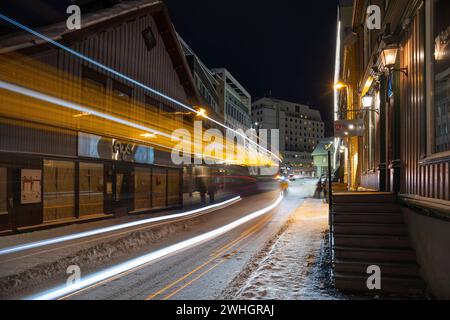 Europa, Norwegen, Tromso, Sjogata (Straße) mit einem Bus, der in der Winterdämmerung an der Weinbar Agenturet vorbeifährt Stockfoto