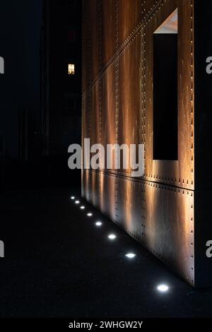 Eine verrostete industrielle Metallwand, beleuchtet durch helle Lampen Stockfoto