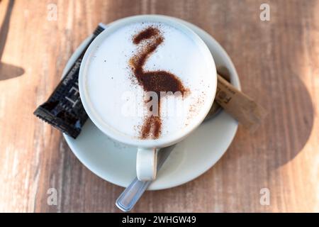 Nahaufnahme eines köstlichen Kaffees mit Milch und einem Camargue Flamingo in Schokoladenpulver Stockfoto