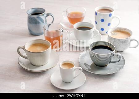 Gruppe von verschiedenen Tassen und Tassen mit Kaffee- und Teegetränken auf einem Lichttisch, ausgewählte Fokussierung Stockfoto