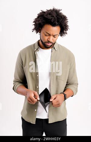 Insolvenzkonzept. Unglücklicher afroamerikanischer Kerl, der mit Traurigkeit und Sorge auf seine leere Brieftasche blickt, isoliert auf weißem Hintergrund steht, frustrierter Mann hat kein Geld Stockfoto