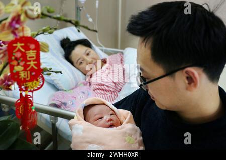 Peking, chinesische Provinz Guangdong. Februar 2024. Ein neugeborenes Baby, dessen chinesisches Tierkreiszeichen Drache ist, wird mit Familienmitgliedern in einem Krankenhaus in Heshan, der südchinesischen Provinz Guangdong, am 10. Februar 2024 gesehen. Nach dem chinesischen Tierkreiszeichen und der chinesischen Tradition symbolisiert das Jahr des Drachen Mut, Glück und Glück. Quelle: Huang Jiming/Xinhua/Alamy Live News Stockfoto