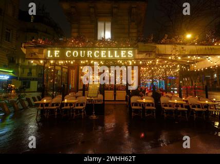 Das Le Courcelles ist ein traditionelles französisches Restaurant in regnerischer Nacht. Es befindet sich am Courcelles Boulevard im 17. Bezirk von Paris. Stockfoto