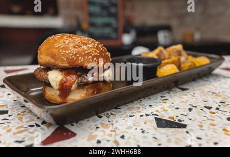 Köstliches Pub-Essen. Burger Und Gläser Bier Auf Holztellern. Abendessen mit Burger und Bier. Stockfoto