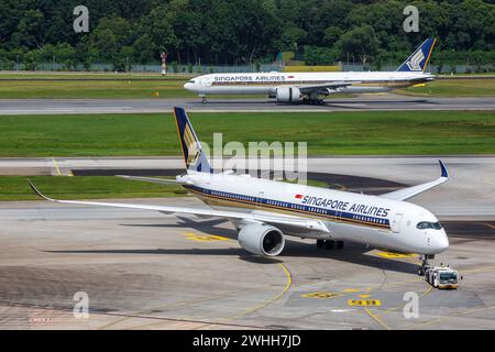 Changi, Singapur - 3. Februar 2023: Flugzeuge der Singapore Airlines A350 und Boeing 777 am Flughafen Changi (SIN) in Singapur. Stockfoto